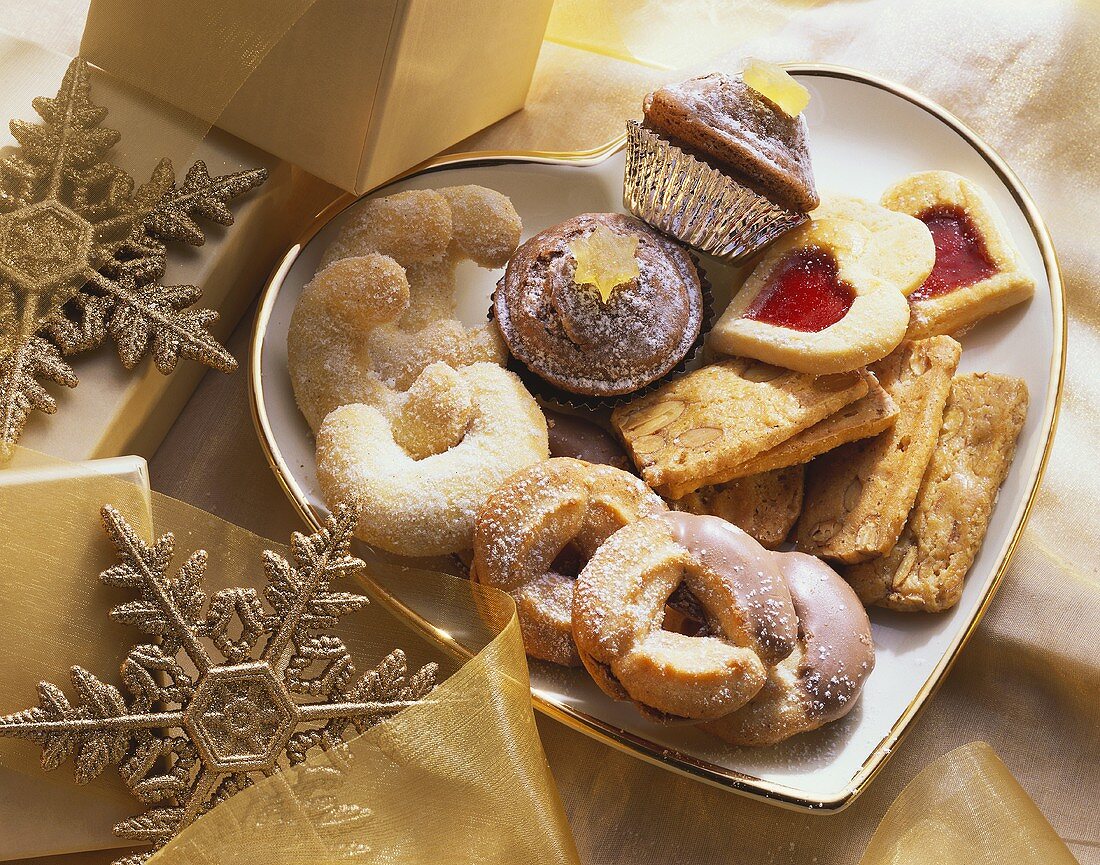 Various Christmas biscuits on heart-shaped plate