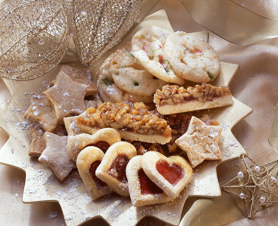 Verschiedene Weihnachtsplätzchen auf goldfarbenem Sternteller