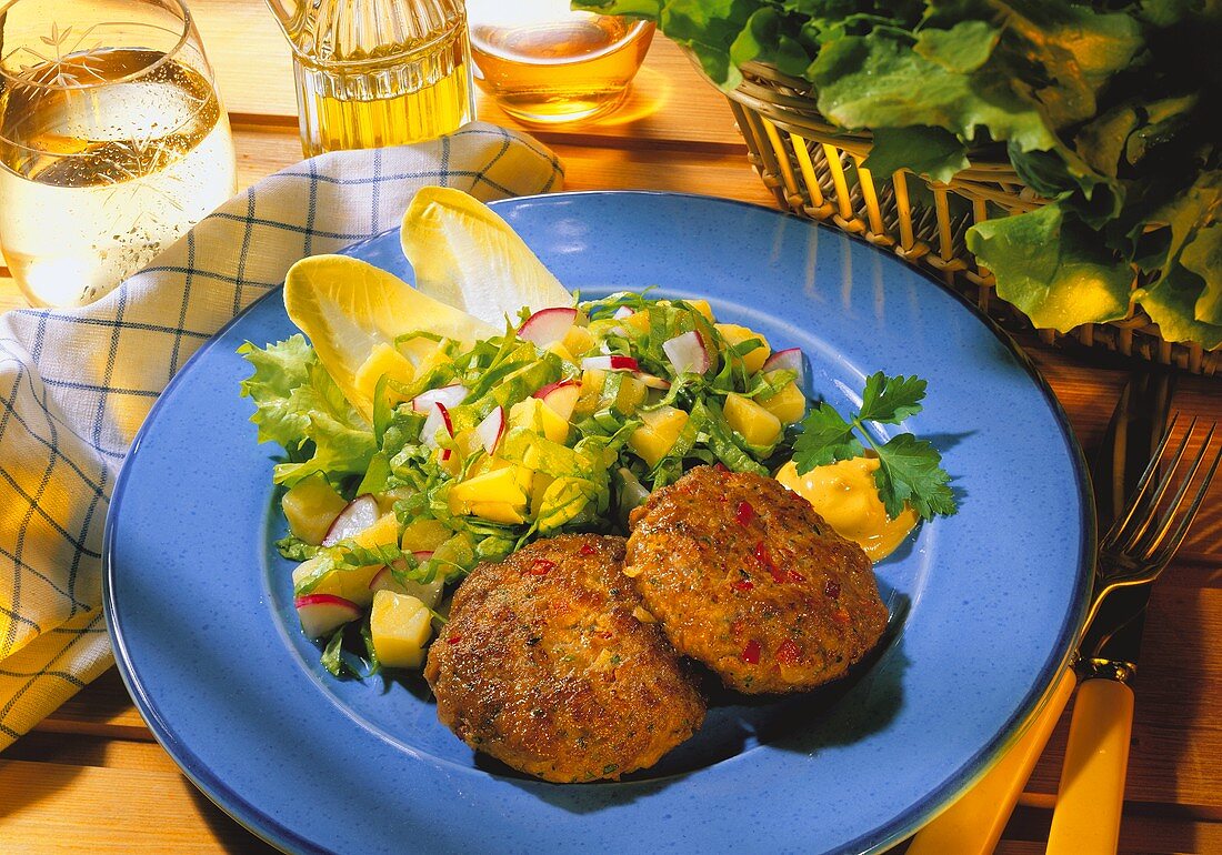 Frikadellen mit Senf und Salat auf Teller