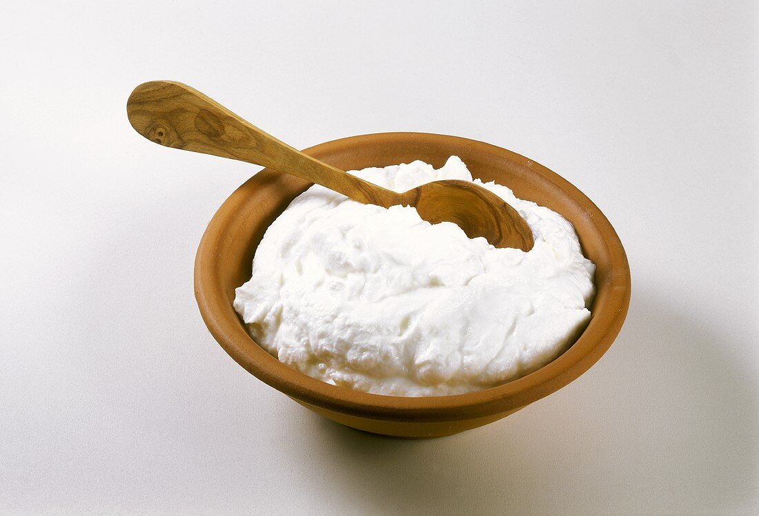 Quark in a clay dish with wooden spoon