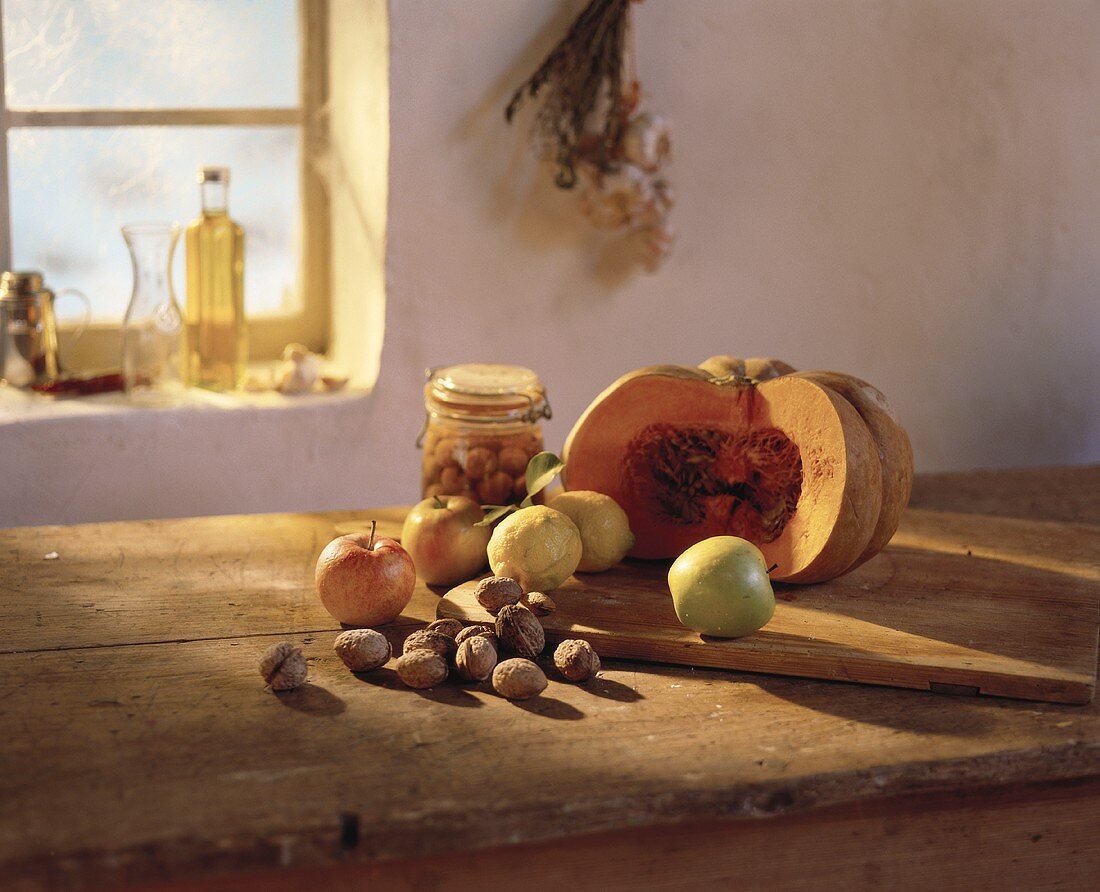 Still life with nuts, apples, lemons & pumpkin on table