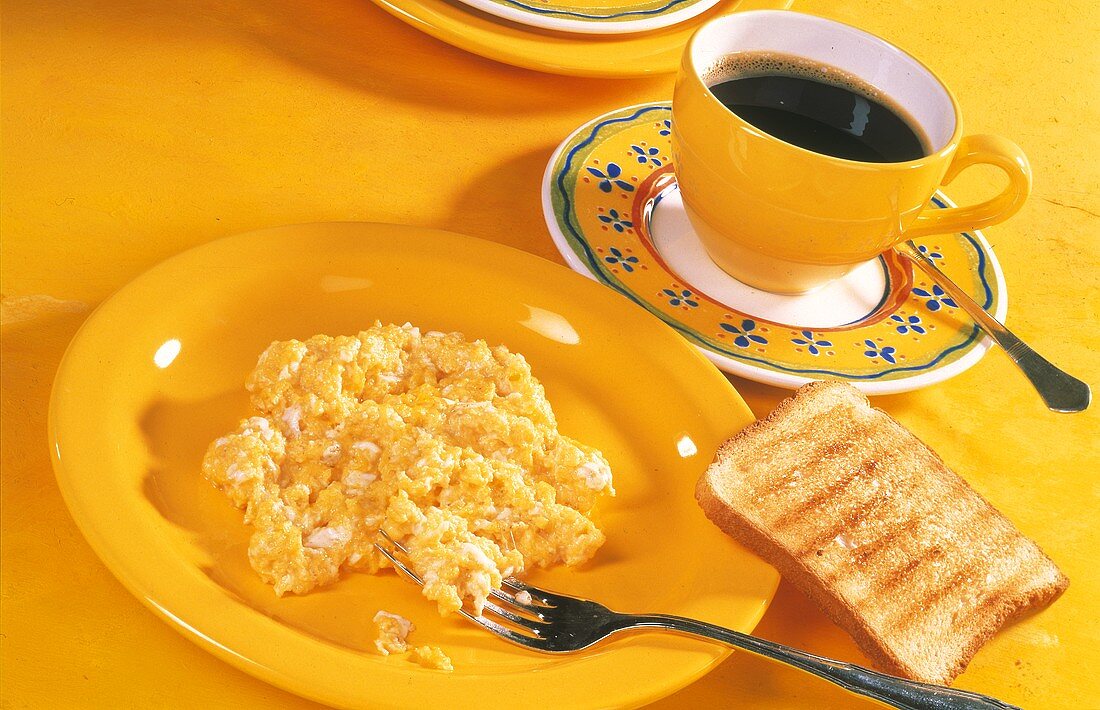 Scrambled egg, slice of toast and a cup of coffee