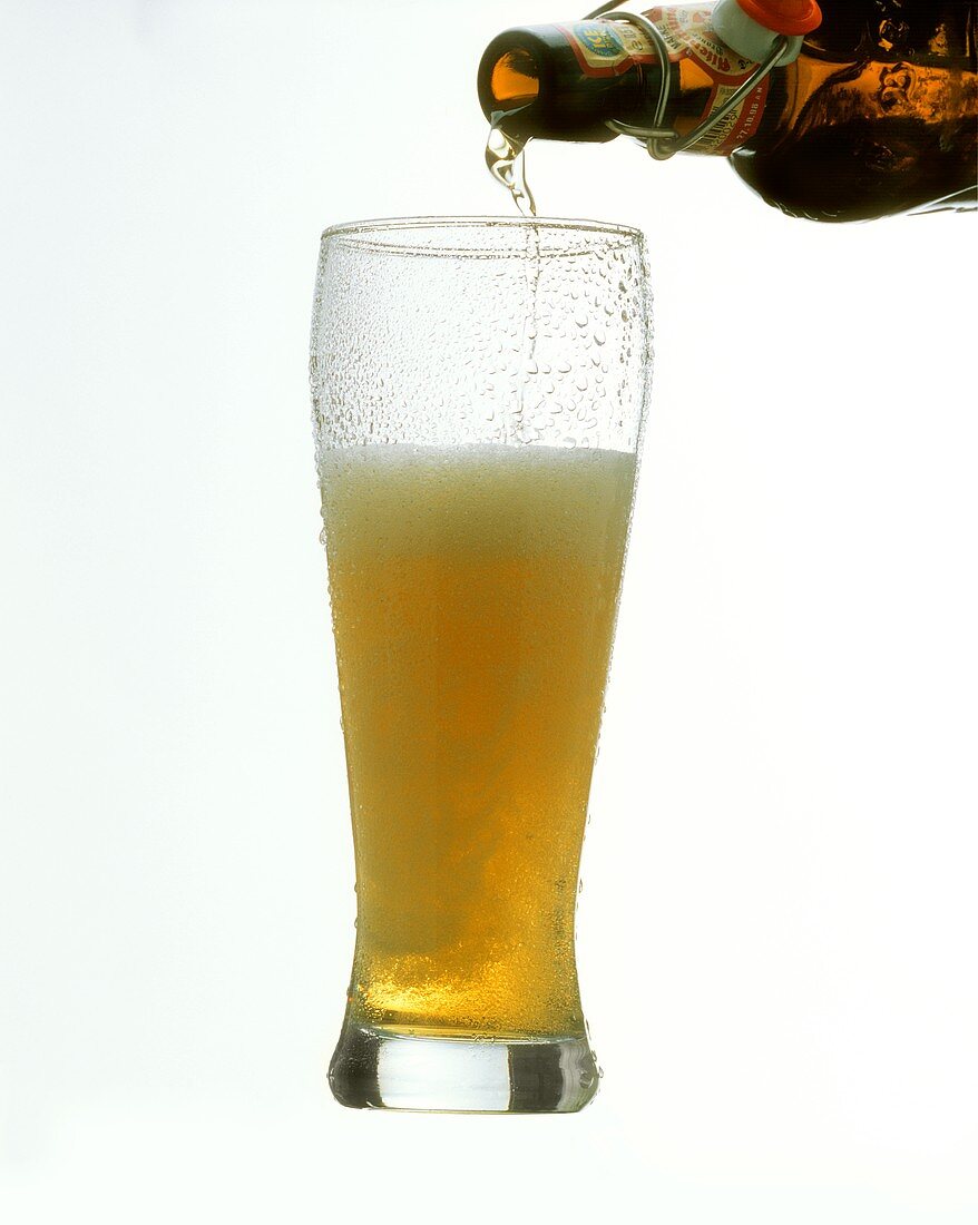 Weissbier aus der Flasche ins Glas einschenken