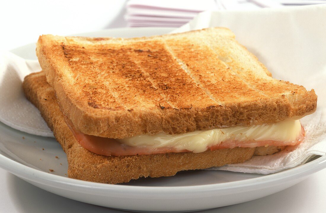 Croque Monsieur (cheese & ham on toast) on white plate