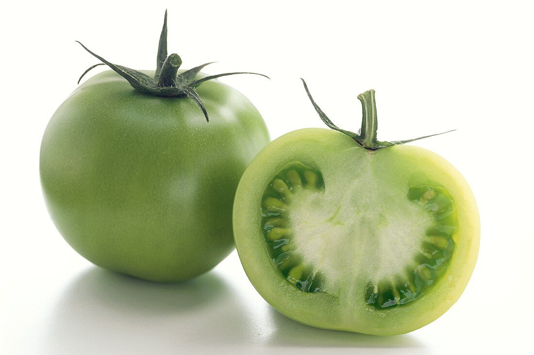 Ganze und halbe grüne Tomate