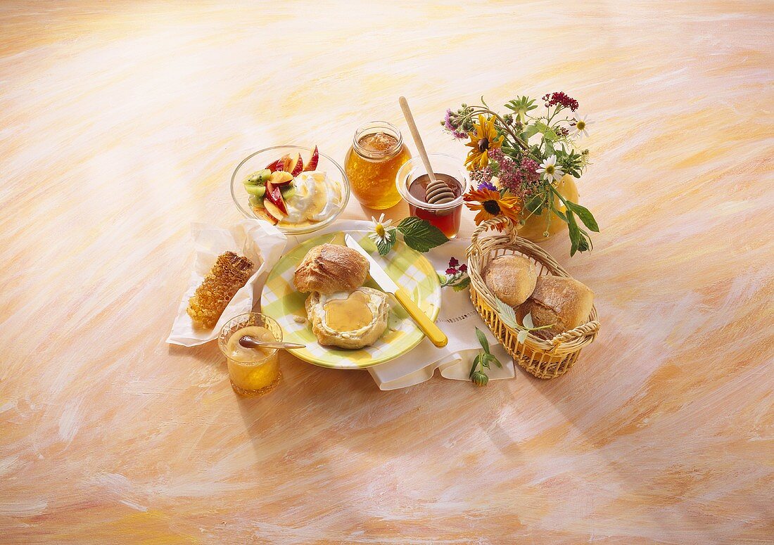 Frühstücksarrangement mit Honig, Honigbrötchen und Honigquark