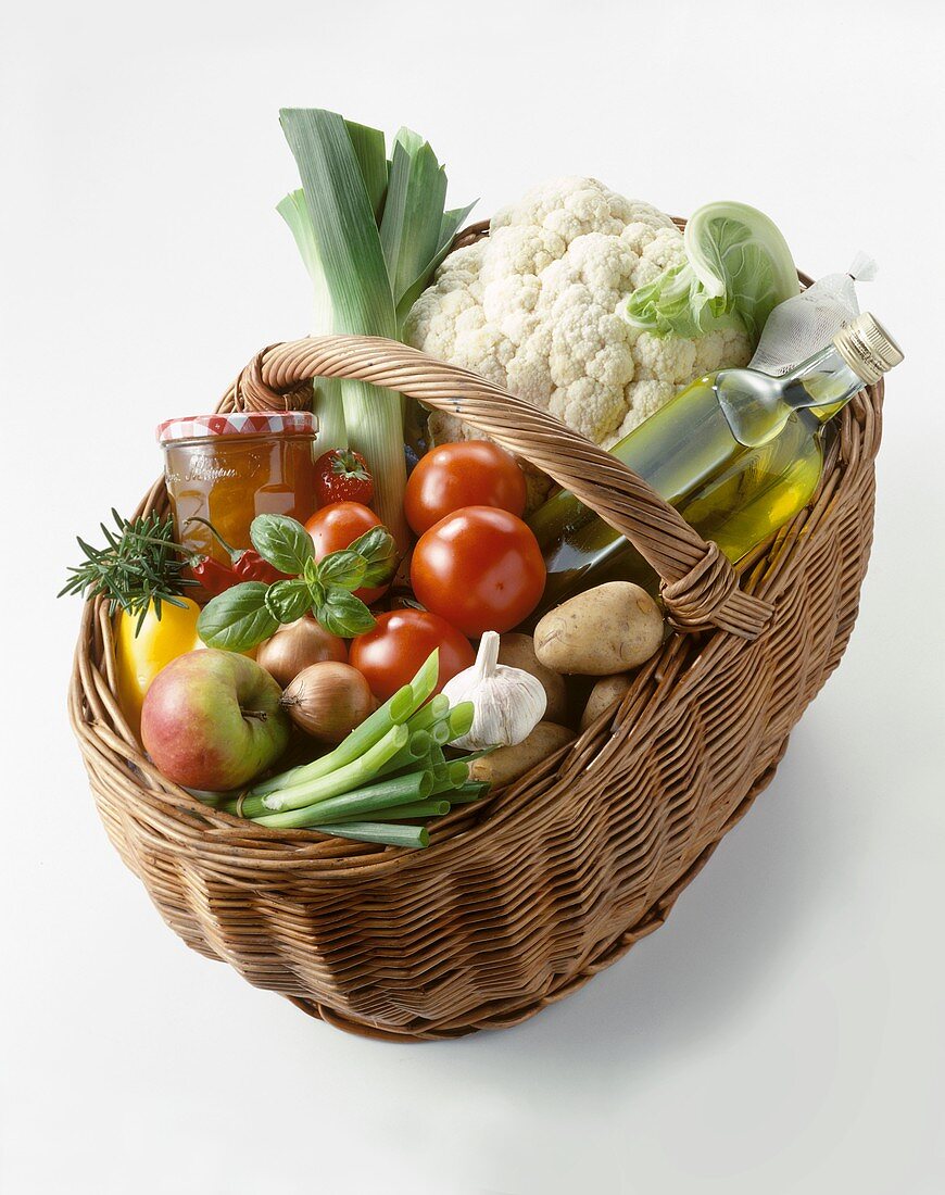 Lebensmittel (Gemüse, Obst, Öl, Marmelade etc.) im Weidenkorb
