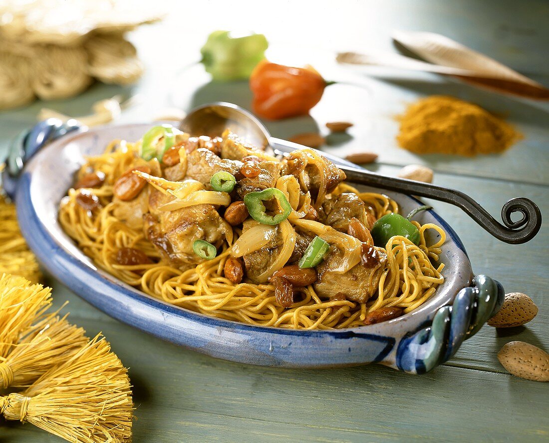 Beef with onions, almonds, raisins on curry noodles