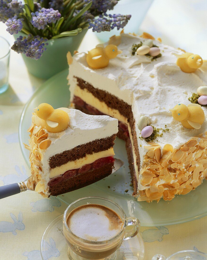 Ostertorte mit Marzipanküken, daneben Milchkaffee