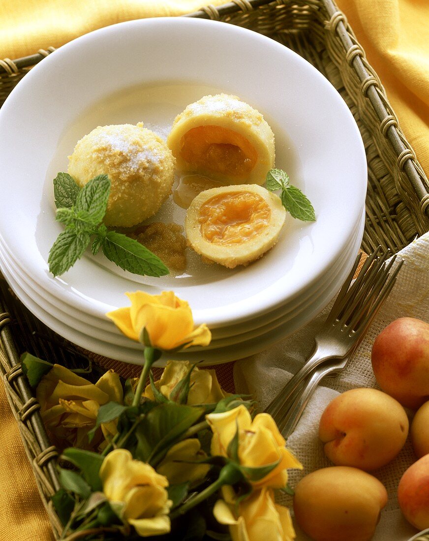 Apricot dumpling on plate; decoration: yellow roses & apricots