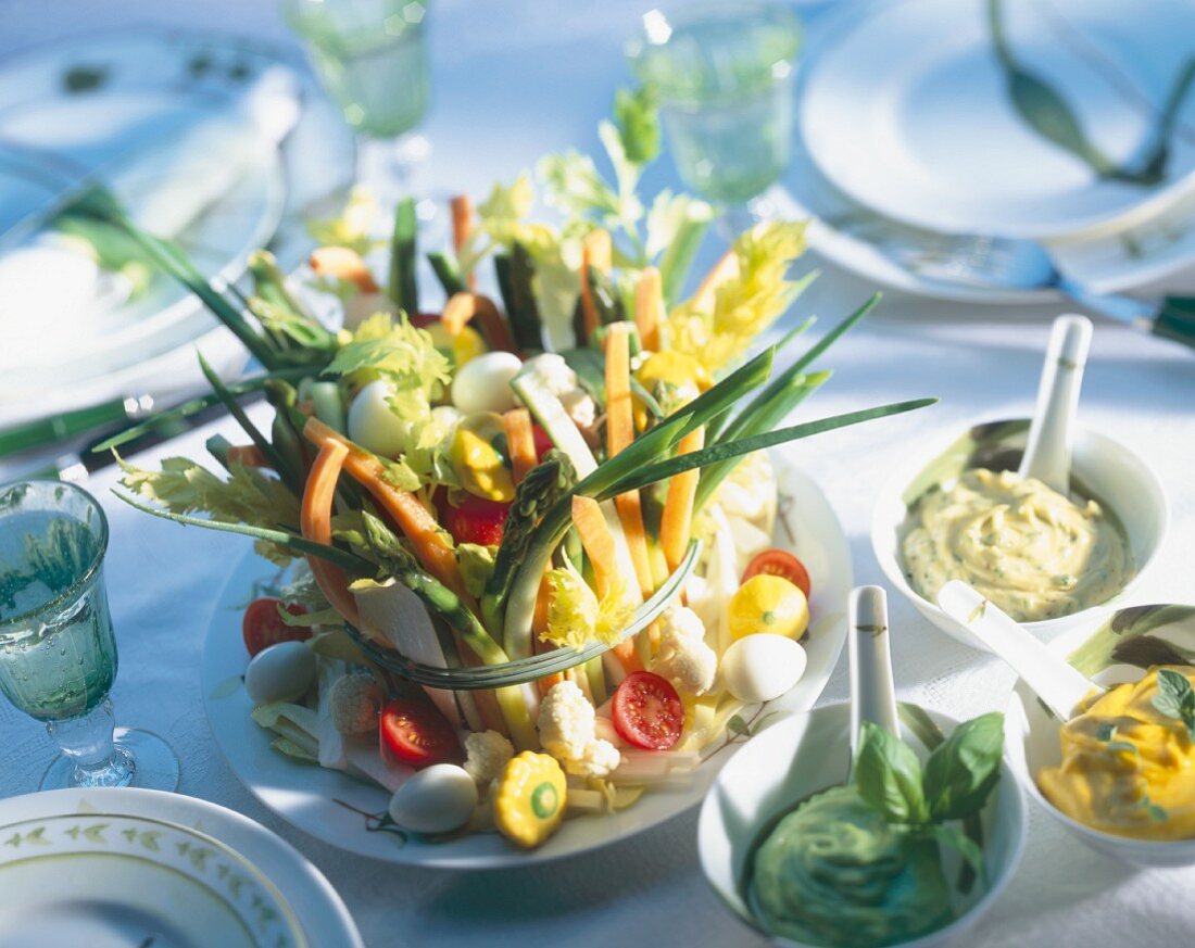 Fresh vegetables sticks for dipping, small eggs, three dips