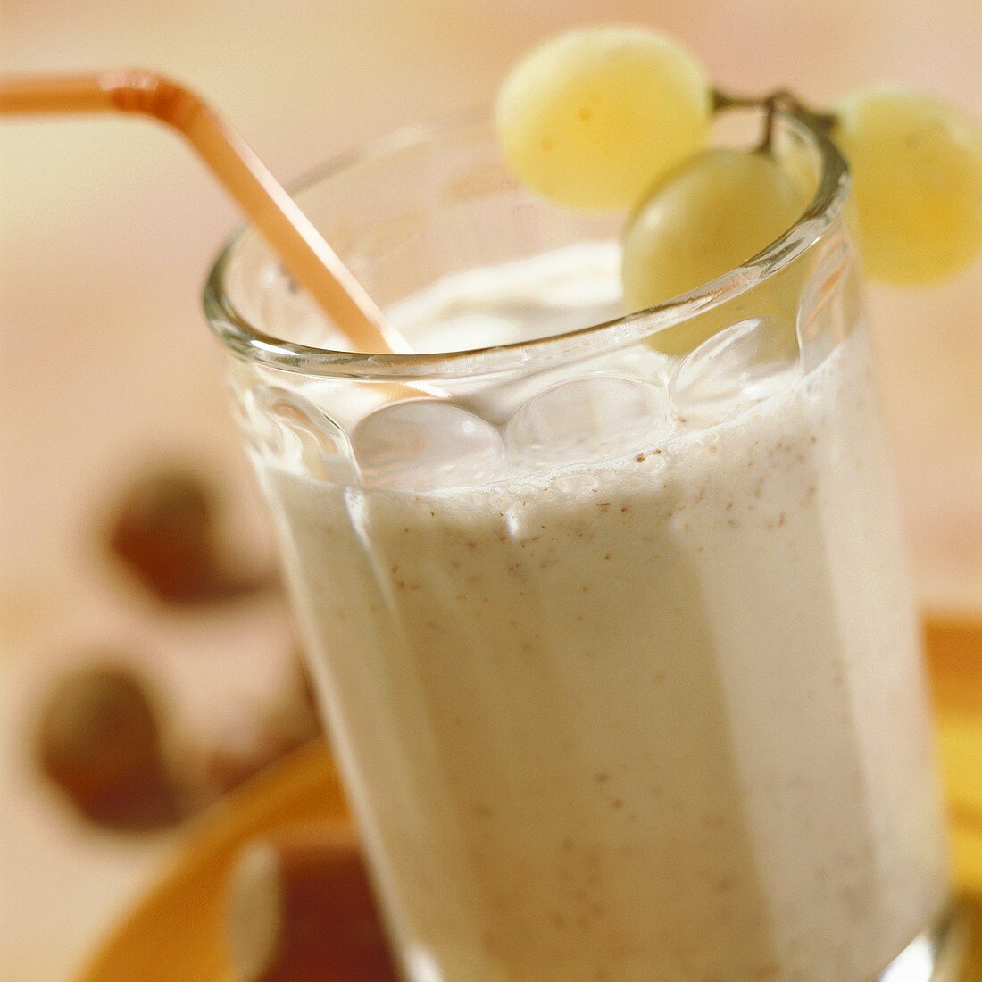 Hazelnut-flavoured milk in glass with straw