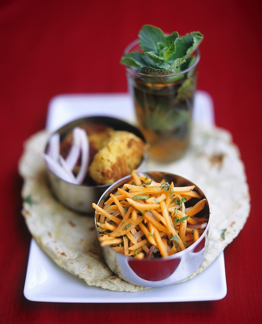 Indian carrot sticks, dumpling and tea on flatbread