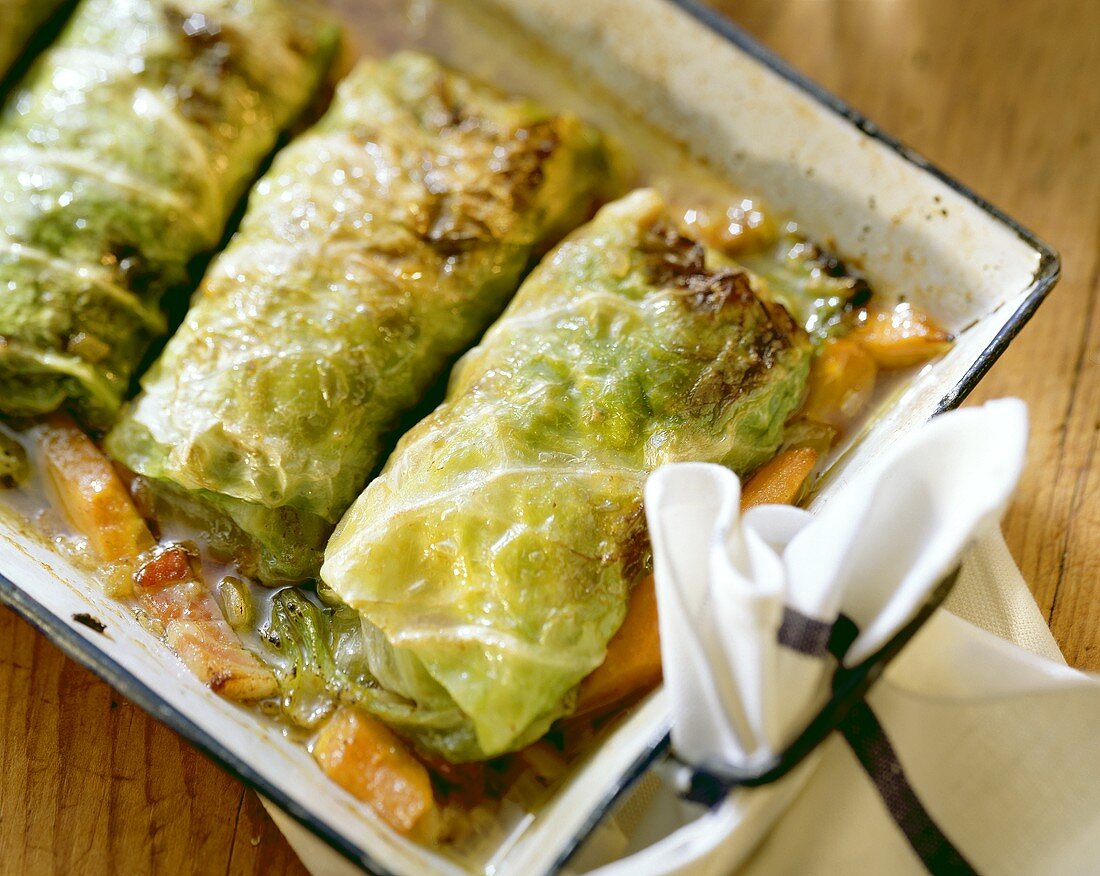 Several cabbage parcels in a roasting dish