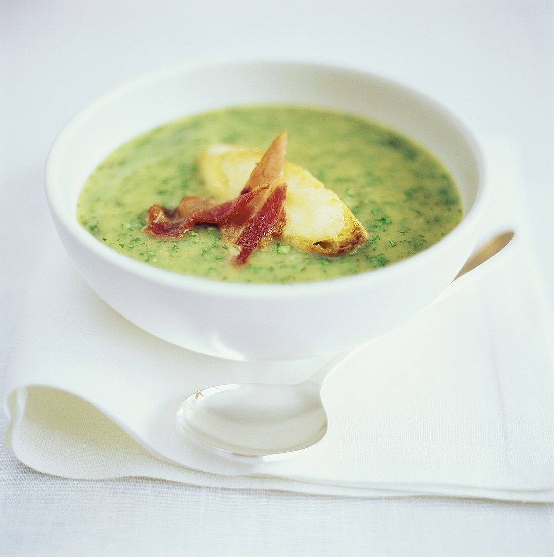 Herb cream soup with bread and bacon