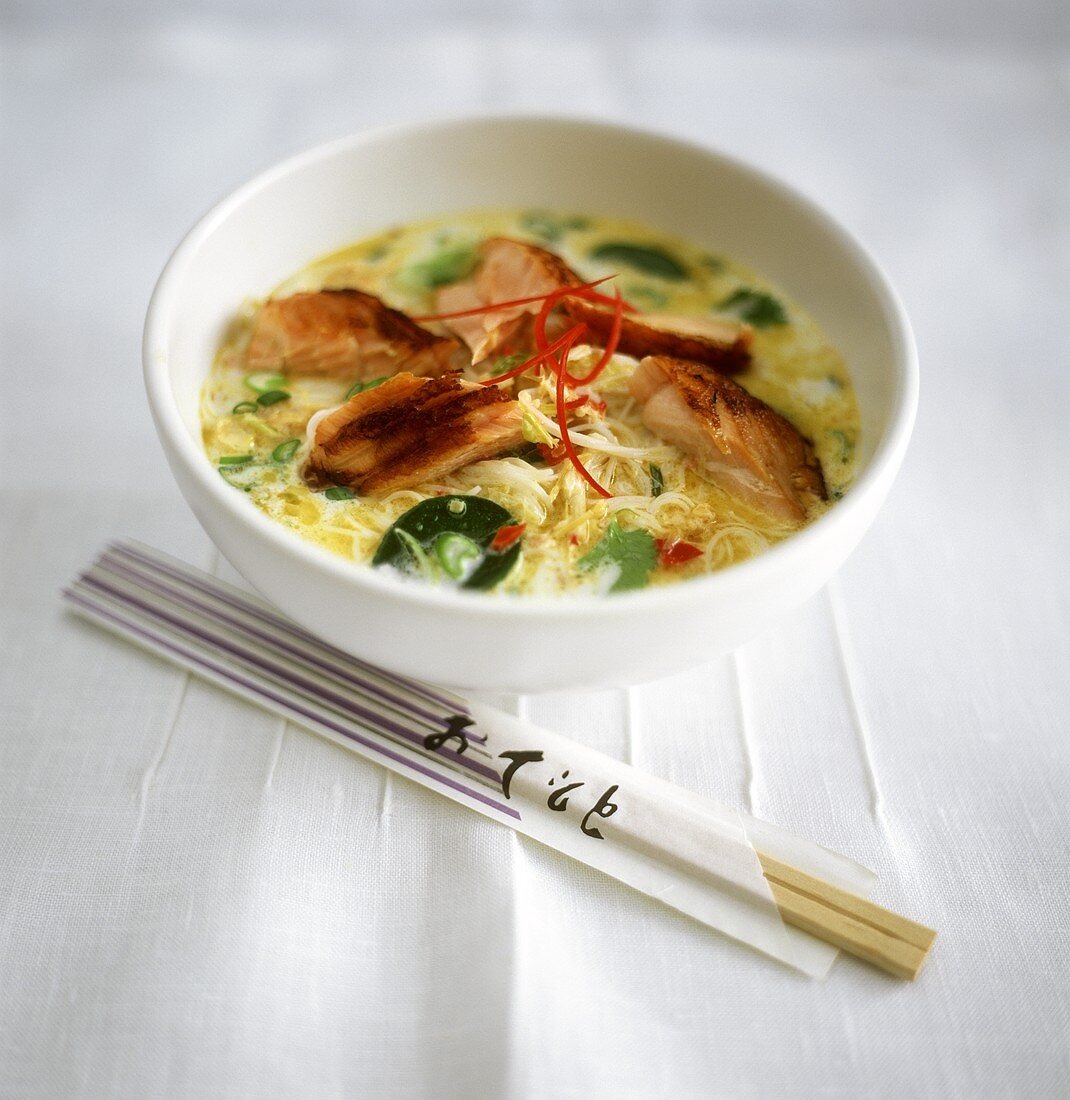 Coconut milk curry with noodles, salmon and lemon leaves