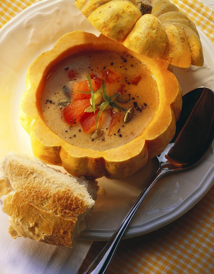 Pumpkin seed soup with tomatoes in hollowed-out pumpkin