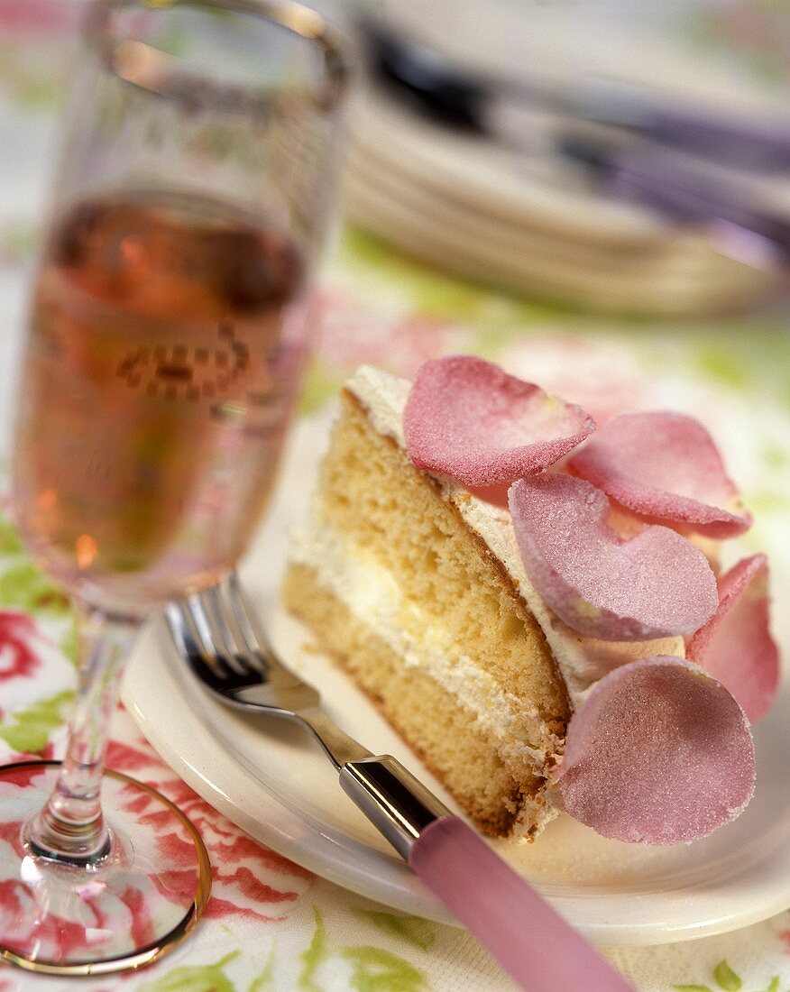 Biskuitkuchen mit Rosencreme und gezuckerten Rosenblättern