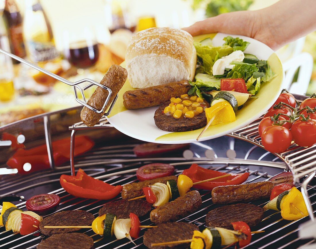 Grilled sausage being laid on plate with tongs