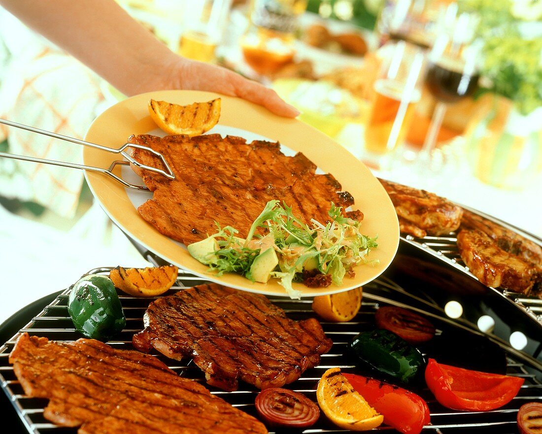 Grilled escalope with grill tongs lying on plate