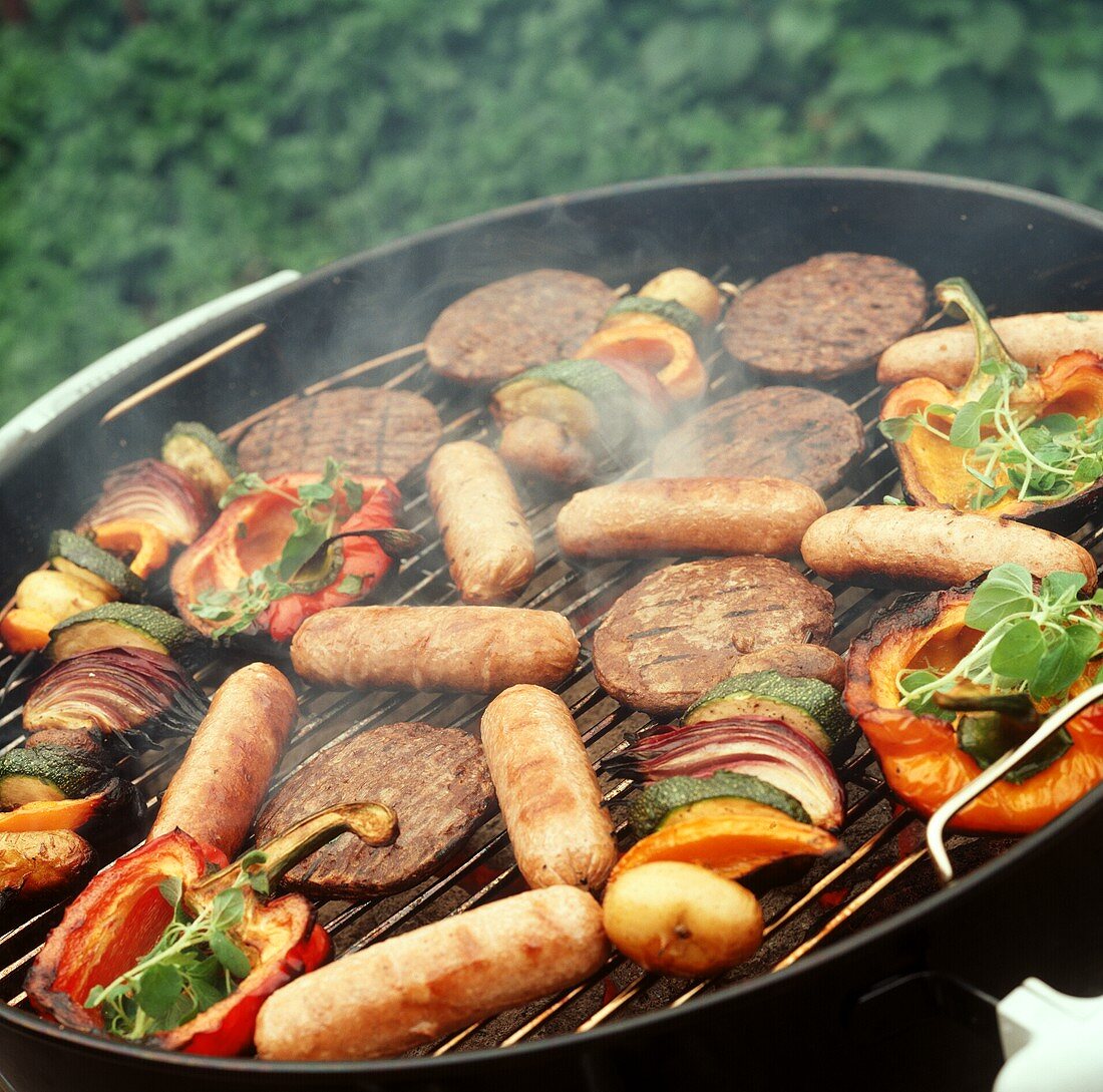 Vegetables, meatballs and sausages on grill