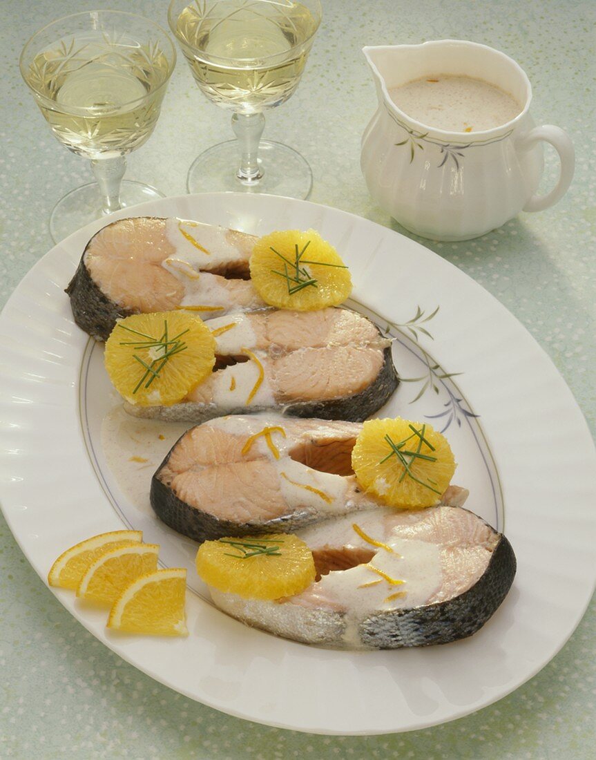Poached salmon cutlets with oranges and cream sauce