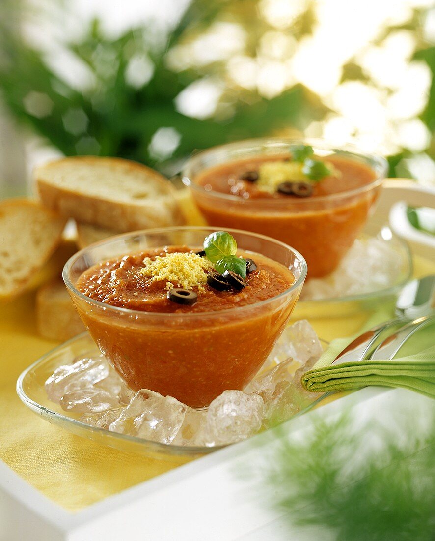 Gazpacho in bowls with olive rings & grated cheese