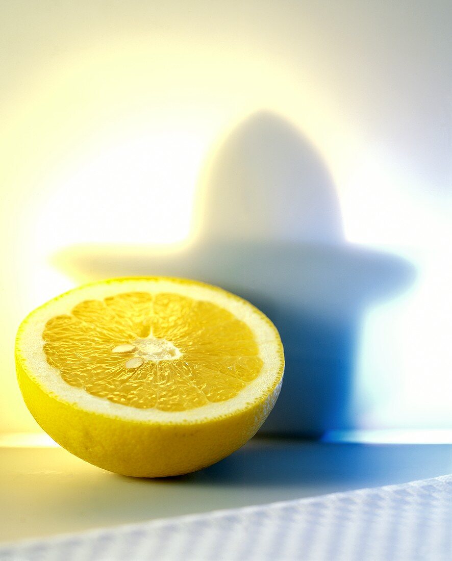 Grapefruit half, with shadow of a juicer in the background 