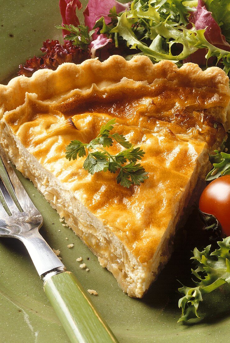 A piece of onion quiche with salad bouquet