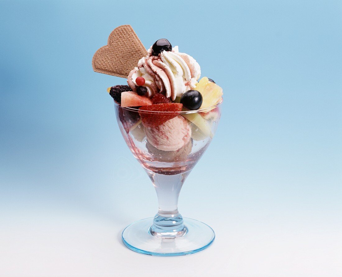 Mixed ice cream sundae with cream, fruit & cherry sauce