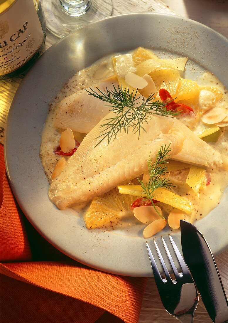Plaice fillets on orange and leek sauce with almonds