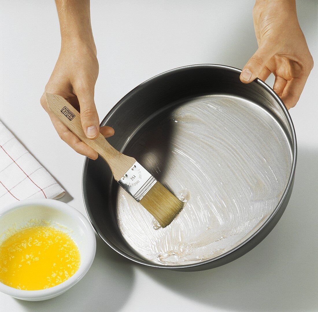 Greasing baking tin with brush and melted butter