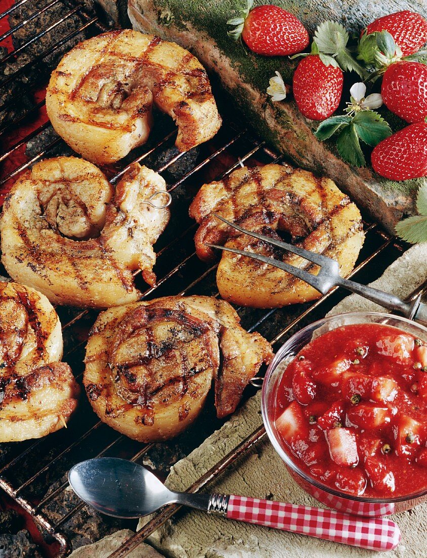 Grilled belly pork on grill rack, strawberry sauce beside it