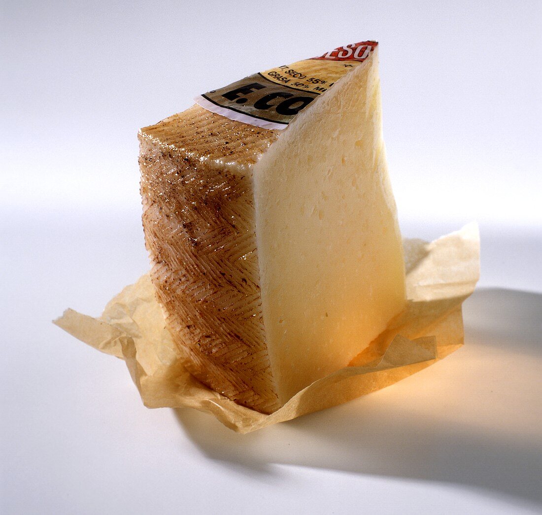 A piece of Manchego on paper (Spanish hard cheese)