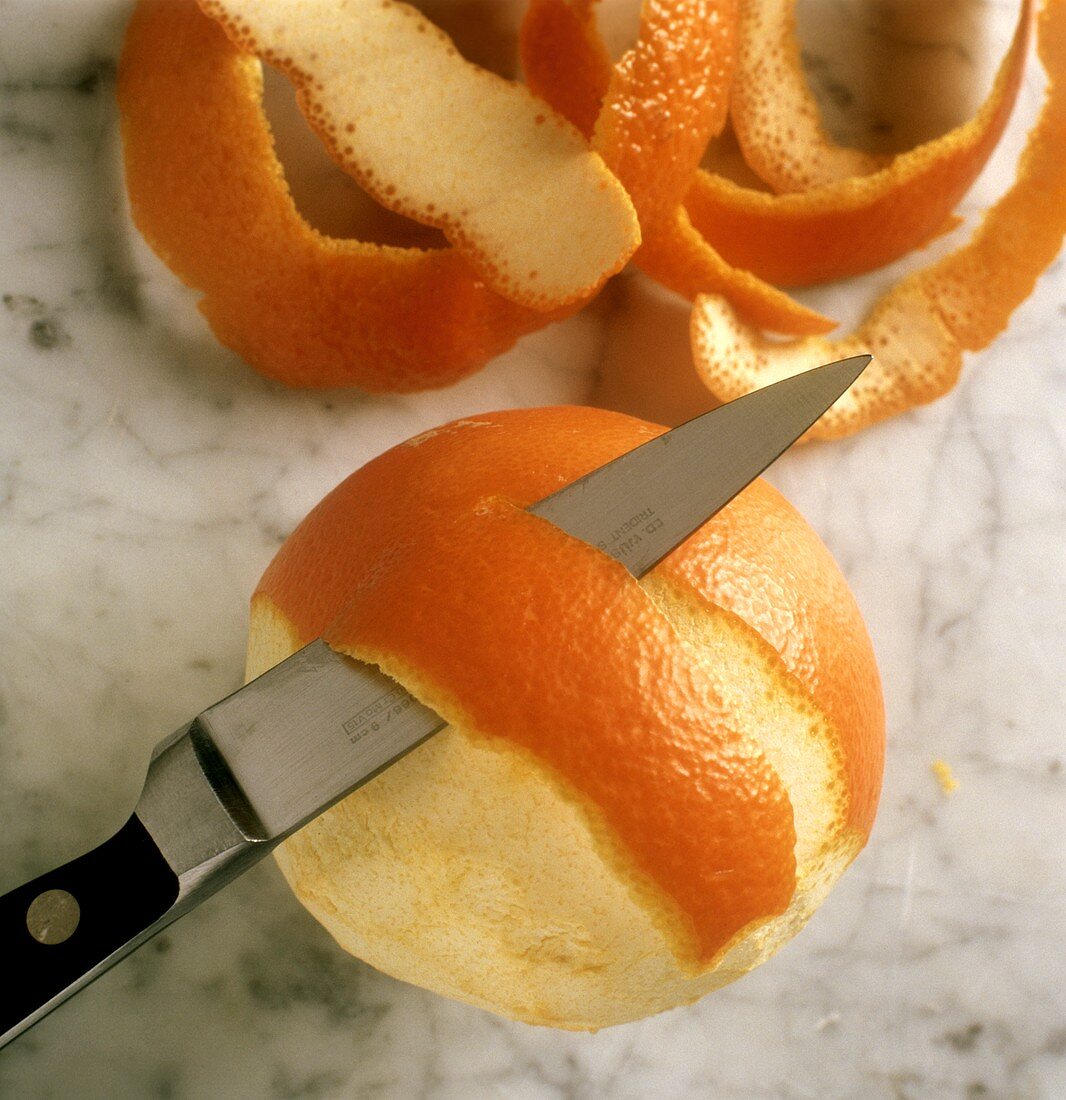 Orange mit Messer schälen