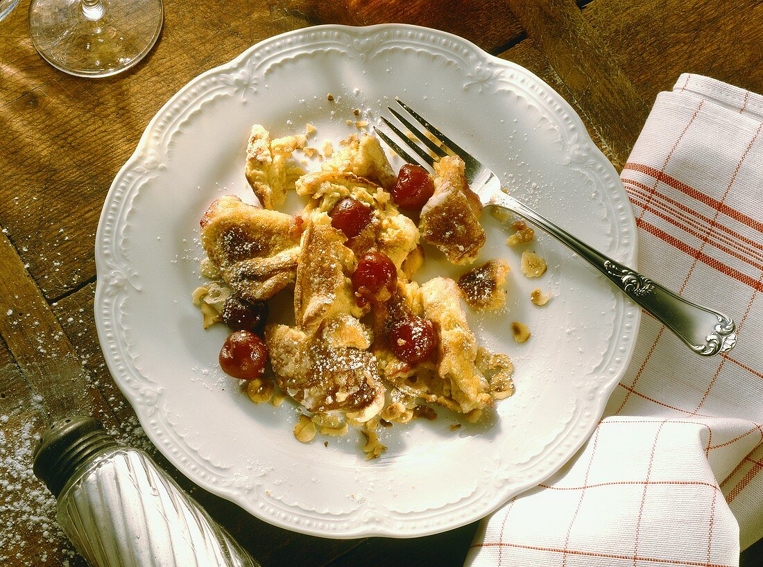 Sour cream and nut pancake with cherries on plate