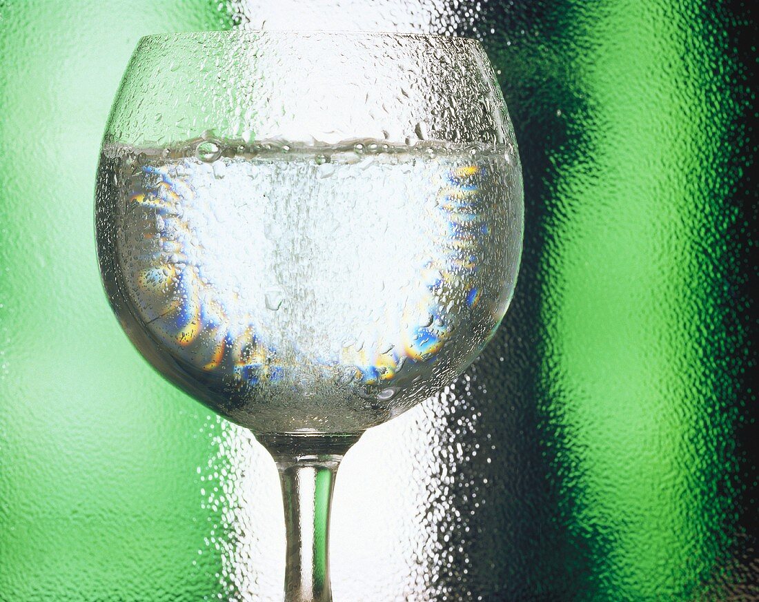 Ein Glas Weißwein mit Wassertropfen (Ausschnitt)