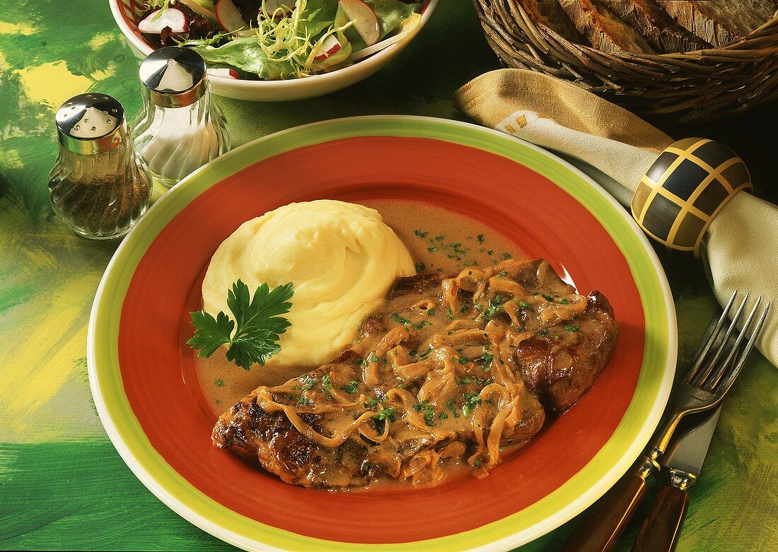 Steak with onions with mashed potato on plate