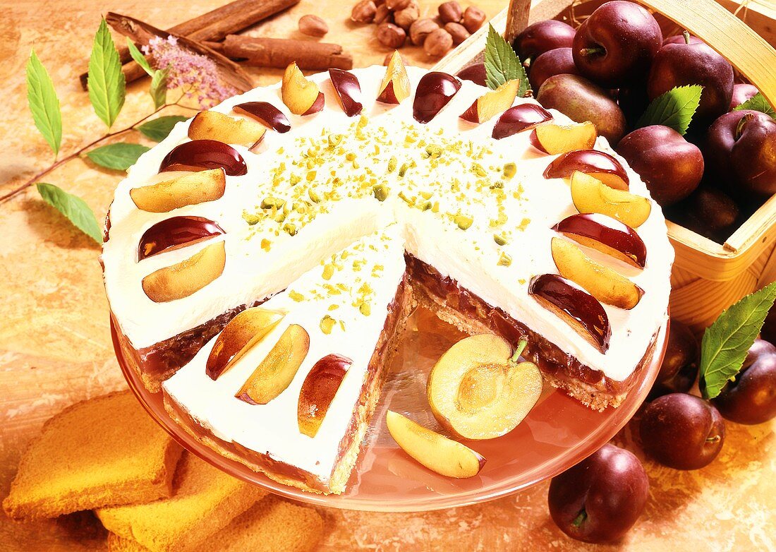 Plum gateau with cream topping and pistachios
