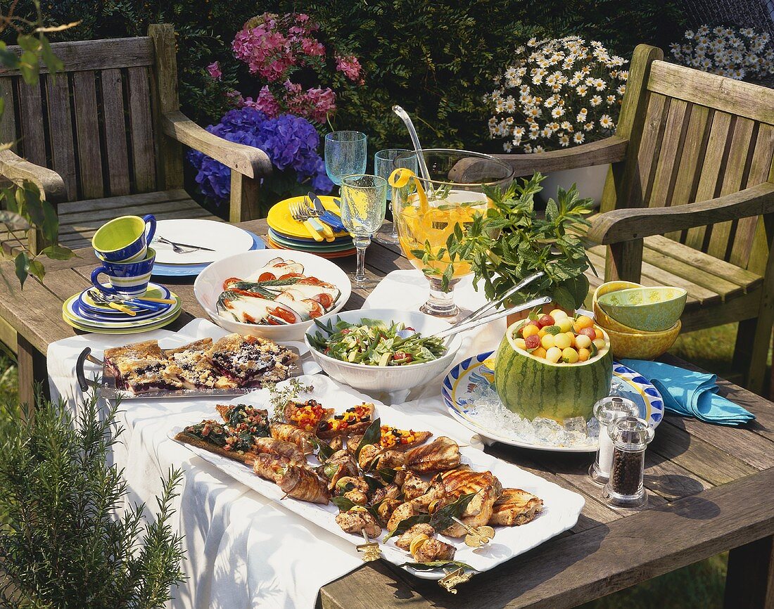 Grillfest im Garten: Tisch mit Grillfleisch & Gerichten