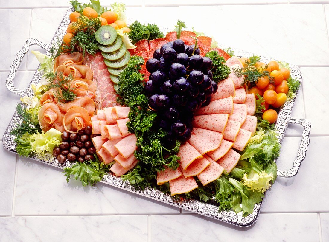 Cold cut platter garnished with salad and fruit