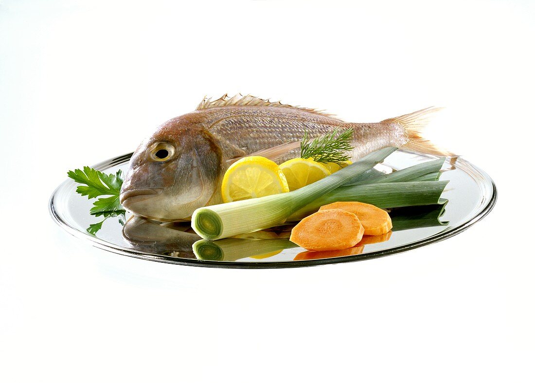 Sea bream with vegetables and lemon slices