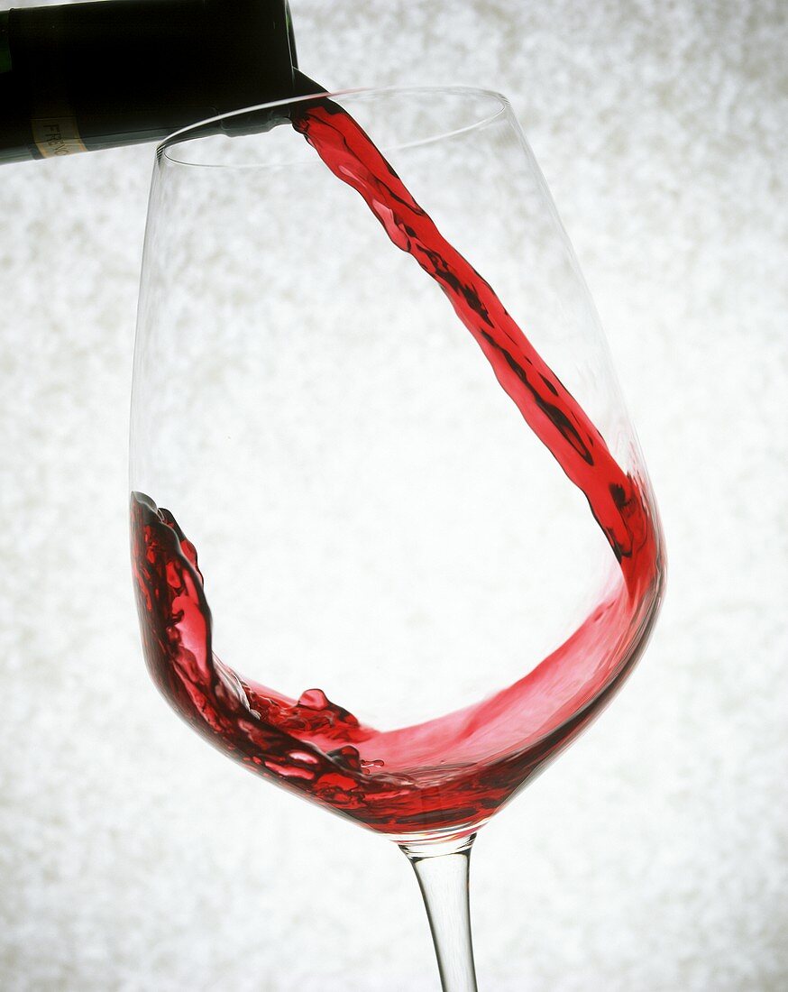 Rotwein in ein Glas einschenken