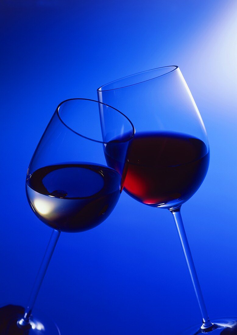 Ein Glas Rotwein und Weißwein beim Zuprosten