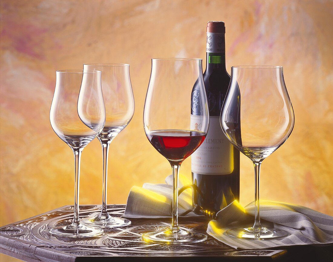 Red wine still life with Bordeaux and glasses on table