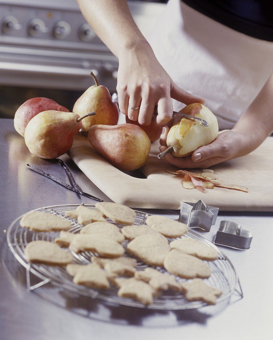Peeling pears, biscuits in foreground