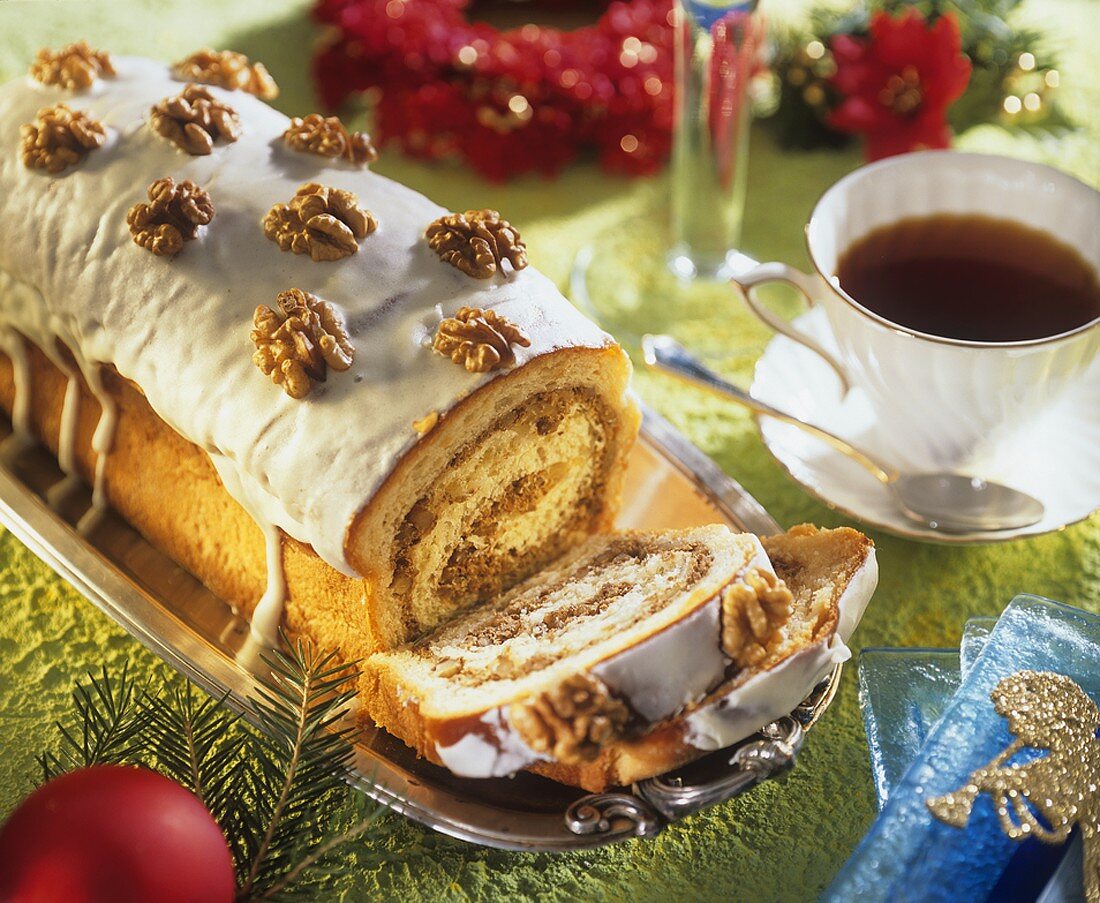 Nut cake roll decorated with glacé icing and walnuts