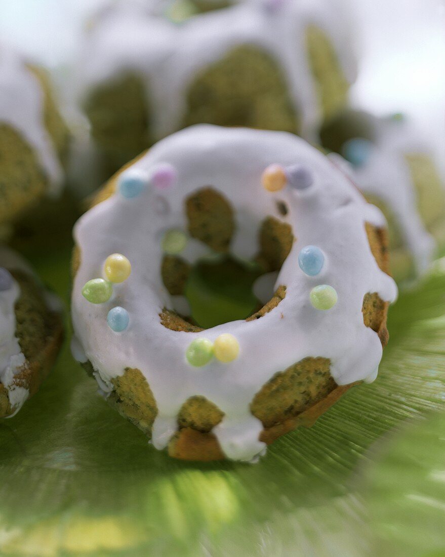 Pistazienküchlein mit Zuckerguss und bunten Zuckerperlen