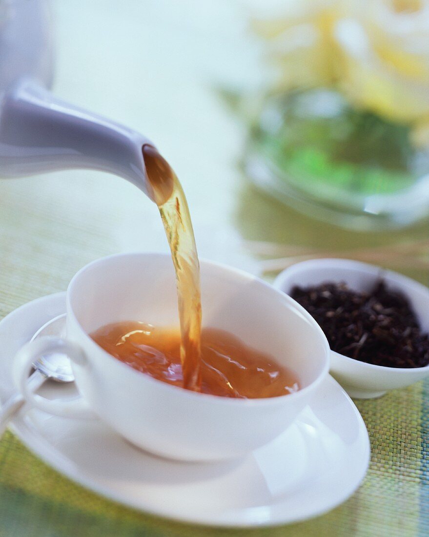 Tea being poured into a tea cup