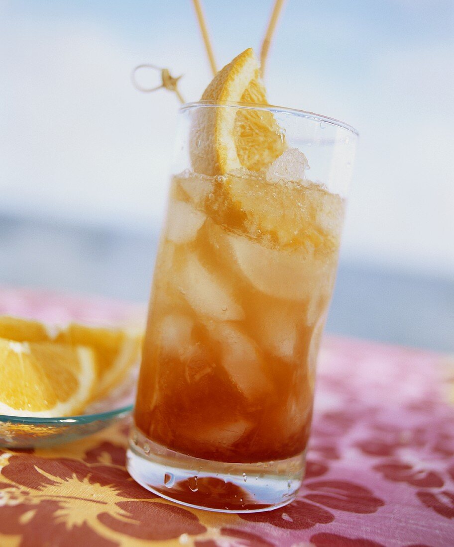 Planter's punch in glass with straws and orange wedges